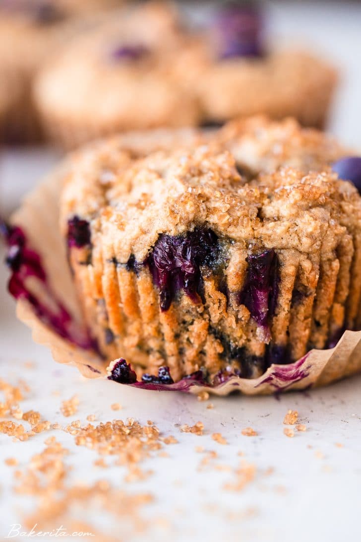 Close up of a blueberry muffin in a parchment paper wrapper.